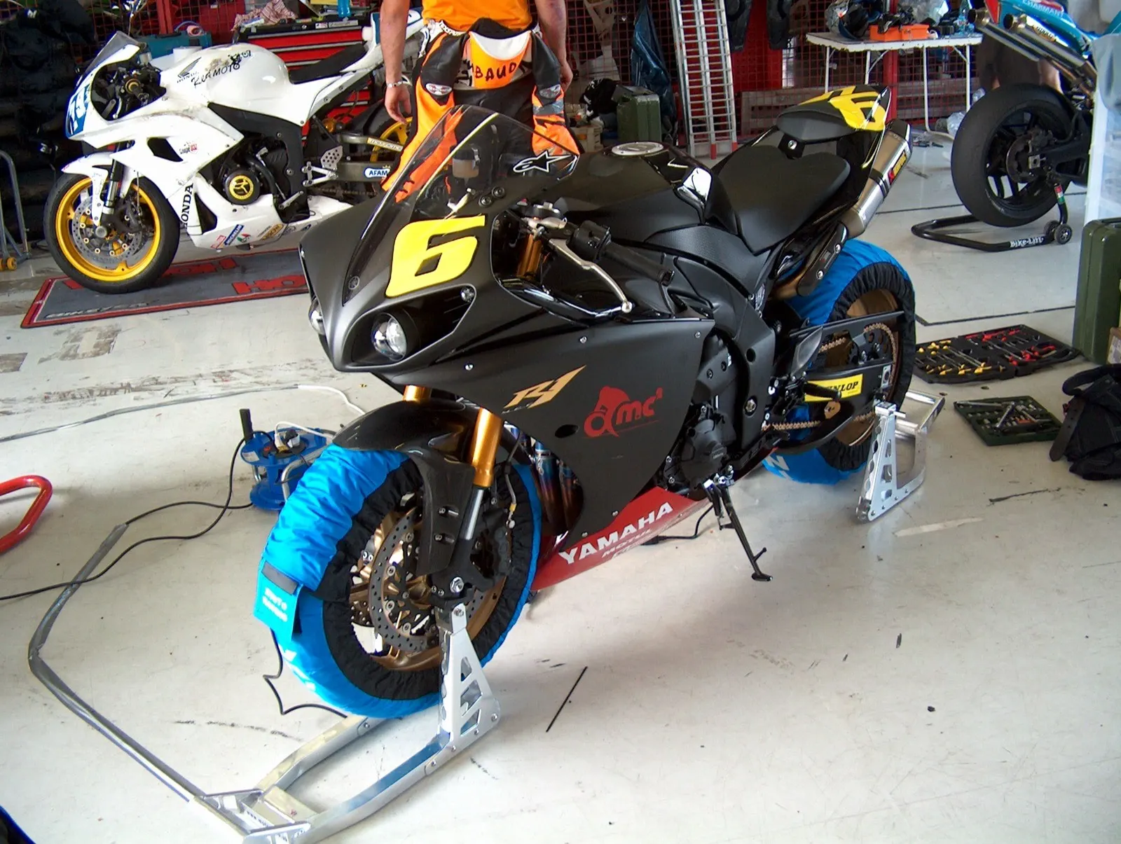 A prepared race bike on tyre warmers in the paddock garage